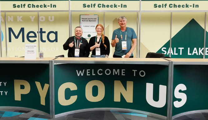 Conference check-in desk with people standing behind it