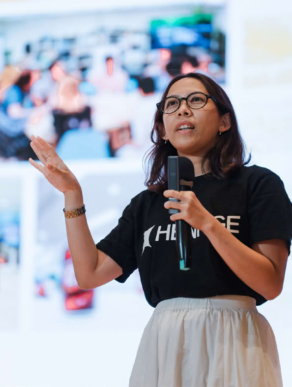 Person speaking on stage with a microphone